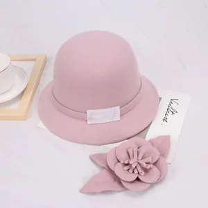 Roze wollen emmerhoed detail met elegant koepelontwerp en prachtig bijpassend bloemaccessoire.