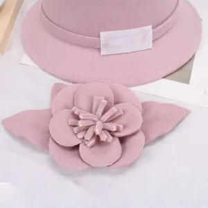 Roze vilt hoed detail met elegante wollen hoed en afneembare bloem broche accessoire.