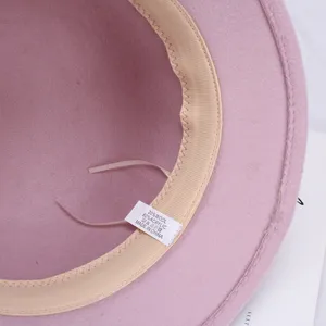 Roze wolmix fedora hoed interieur detail weergave met voering en samenstellingslabel.