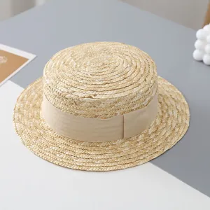 Vista detallada de un sombrero de paja clásico de copa plana con cinta beige para niños.