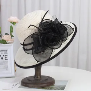 Close-up detail of the elegant beige wide-brim sun hat with black floral mesh decor.