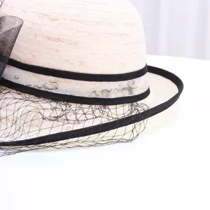 Gros plan détaillé d'un chapeau cloche en dentelle beige élégant avec ruban noir et voile fin.