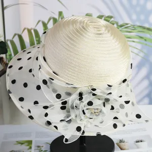 Close-up view of elegant organza polka dot mesh hat with floral detail and breathable brim.