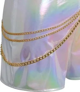 Close-up shot of holographic white stage costume fabric featuring stylish layered gold chains detail.