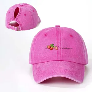 Pink washed ponytail baseball cap with cute strawberry print and adjustable back metal buckle.