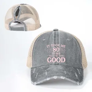 Distressed grey ponytail trucker hat with mesh back and funny 80th birthday graphic print.