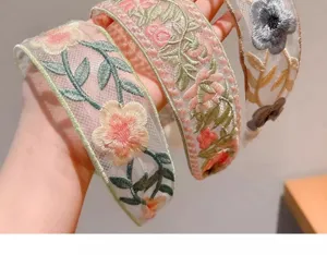 Detailed view of the elegant mesh embroidered floral headband, showing delicate craft.