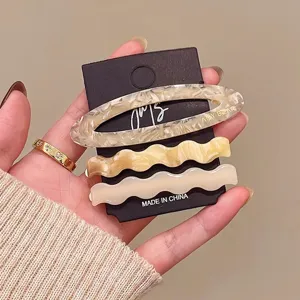 Detail view of 3-piece acetate hair clip set featuring elegant wavy and oval cutout designs.