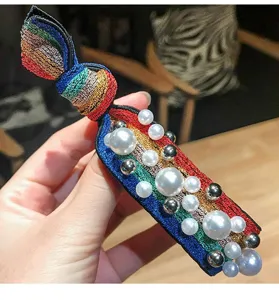 Primo piano dettagliato di un elastico per capelli in tessuto arc-en-ciel con perle.