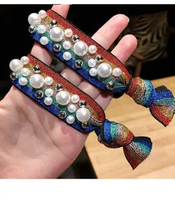Vista dettagliata di un elastico per capelli in tessuto arcobaleno colorato decorato con perle.