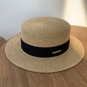 Sombrero de paja plano para mujer con cinta negra, borde corto elegante para la playa.