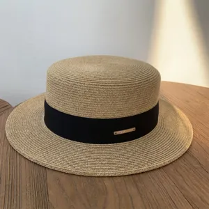 Sombrero de paja plano con cinta negra y placa de metal para verano, playa y uso al aire libre.
