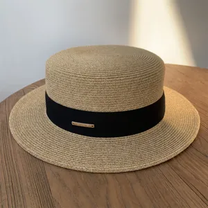 Vista detallada del sombrero de paja para mujer con tejido fino, cinta negra y detalle metálico.