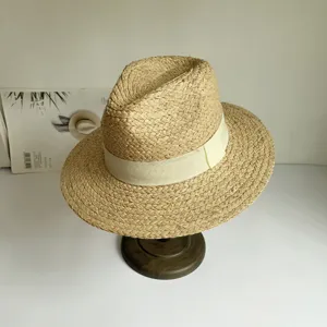 Nahaufnahme Detail des handgeflochtenen Strohhutes mit beigen Band, eleganter Urlaubsstil.