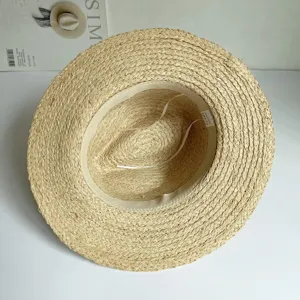 Detailansicht des handgepflochtenen Raffia-Strohhutes innen, feine natürliche Textur.