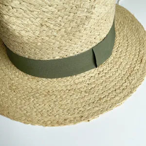 Nahaufnahme des handgeflochtenen Bast-Strohhutes mit olivgrünem Band. Sommer Sonnenhut.