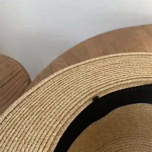 Primer plano de la textura trenzada del sombrero de paja y la banda de sudor negra.