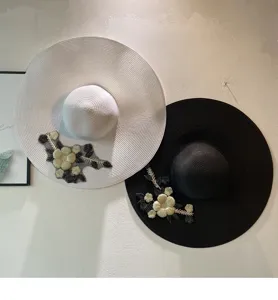 Detailansicht von Sonnenhüten mit breiter Krempe, feiner Blumenstickerei und Netzapplikation.
