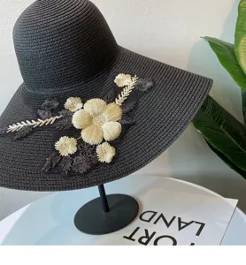 Damen breiter schwarzer Strohhut mit Blumenstickerei für den sonnigen Strandurlaub und Sommer.