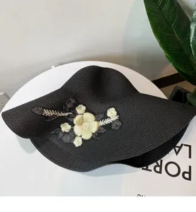 Schwarzer Strohhut mit breiter Krempe und edler goldener Blumenstickerei für den Sommer.