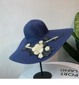 Detailansicht eines eleganten dunkelblauen Sonnenhutes mit wunderschöner Blumenstickerei.