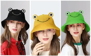 Close-up details of cute frog bucket hats in black, yellow and green with adorable embroidered smiles.