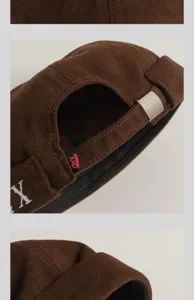 Détail de bonnet docker en velours côtelé marron avec logo brodé et boucle en métal.