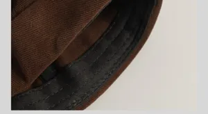 Gros plan sur le tissu et les coutures de bonnet docker marron de belle qualité.