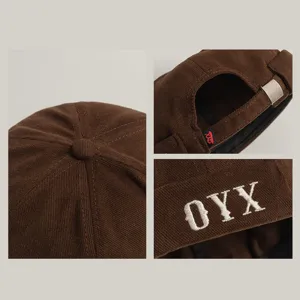 Chapeau docker marron en velours côtelé avec broderie de lettres OYX et boucle en métal.
