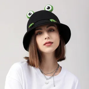 Close-up of black bucket hat featuring funny 3D cartoon frog eyes and cute little green legs.