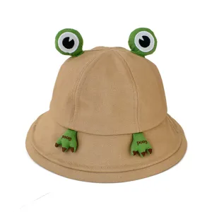 Cute frog bucket hat detailed view, khaki cotton fabric with funny frog eyes and paws.