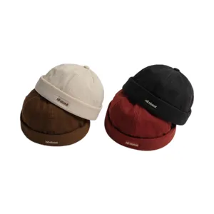 Retro Docker Cap Detail mit vier farbigen Rollmützen und gesticktem Etikettendesign.