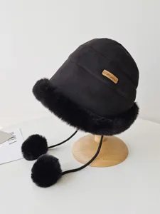 Detailed view of black faux suede bucket hat with plush faux fur trim and cute pom pom ties.