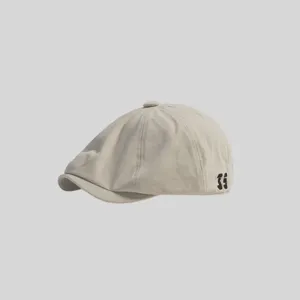 Detalle de gorra boina beige clásica, elegante sombrero plano retro para uso diario y casual.