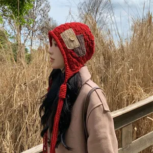 Detailed view of the red handmade crochet earflap beanie with cute tassels and patch.