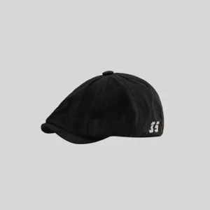 Primer plano detalle de una gorra plana negra casual con gráfico blanco lateral, estilo.
