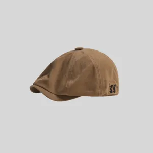 Primer plano detallado de la gorra plana marrón con bordado lateral, elegante tocado vintage.