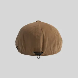 Vista detallada de la gorra plana marrón de lona con cordón ajustable y ojales metálicos.