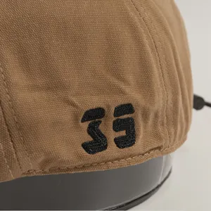 Detalle de gorra plana de lona marrón estilo coreano, boina vintage casual con bordado único.