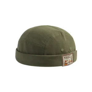 Detail view of olive green docker cap with woven mountain patch and textured canvas fabric.