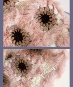 Handgemachte flauschige Häkelblumen Winter Fischerhut Detail Nahaufnahme rosa Wolle Textur.