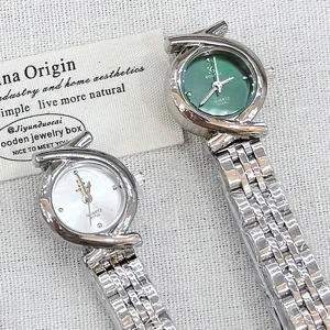 Dettaglio in primo piano dell'orologio al quarzo da donna con quadrante verde e cinturino.