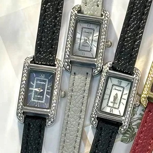 Detailed close-up shot of elegant rectangular quartz wristwatches with rhinestone bezels.