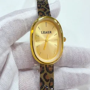 Elegante orologio da polso al quarzo da donna ovale con cassa dorata e cinturino leopardato.
