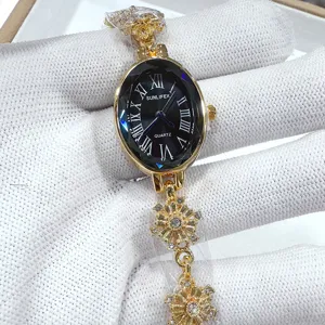 Elegant women's oval quartz watch with black Roman dial and gold snowflake chain strap detail.