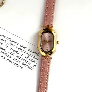 Detailed shot of a vintage style women quartz watch with pink leather strap and gold oval case.