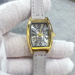 Women tonneau quartz watch with light grey leather strap and classic arabic numeral dial.