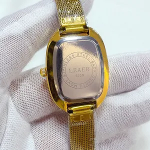 Vista ravvicinata dettagliata del retro dell'orologio al quarzo ovale dorato con maglia.