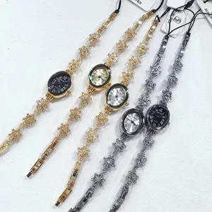 Detail view of elegant women oval quartz bracelet watch with sparkling rhinestone snowflake chain links.