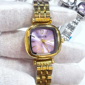 Dettaglio quadrante orologio quadrato donna dorato, quadrante viola, cinturino metallo.